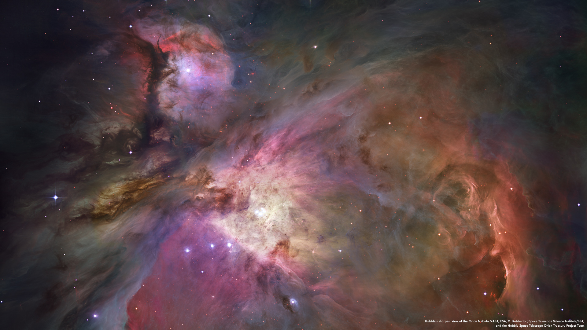This dramatic image offers a peek inside a cavern of roiling dust and gas where thousands of stars are forming. The image, taken by the Advanced Camera for Surveys (ACS) aboard NASA/ESA Hubble Space Telescope, represents the sharpest view ever taken of this region, called the Orion Nebula. More than 3,000 stars of various sizes appear in this image. Some of them have never been seen in visible light. These stars reside in a dramatic dust-and-gas landscape of plateaus, mountains, and valleys that are reminiscent of the Grand Canyon. The Orion Nebula is a picture book of star formation, from the massive, young stars that are shaping the nebula to the pillars of dense gas that may be the homes of budding stars. The bright central region is the home of the four heftiest stars in the nebula. The stars are called the Trapezium because they are arranged in a trapezoid pattern. Ultraviolet light unleashed by these stars is carving a cavity in the nebula and disrupting the growth of hundreds of smaller stars. Located near the Trapezium stars are stars still young enough to have disks of material encircling them. These disks are called protoplanetary disks or "proplyds" and are too small to see clearly in this image. The disks are the building blocks of solar systems. The bright glow at upper left is from M43, a small region being shaped by a massive, young star's ultraviolet light. Astronomers call the region a miniature Orion Nebula because only one star is sculpting the landscape. The Orion Nebula has four such stars. Next to M43 are dense, dark pillars of dust and gas that point toward the Trapezium. These pillars are resisting erosion from the Trapezium's intense ultraviolet light. The glowing region on the right reveals arcs and bubbles formed when stellar winds - streams of charged particles ejected from the Trapezium stars - collide with material. The faint red stars near the bottom are the myriad brown dwarfs that Hubble spied for the first time in the nebula in visible light