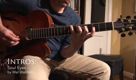 Matt playing his Sadowsky archtop in his office at night with a warm colored light.